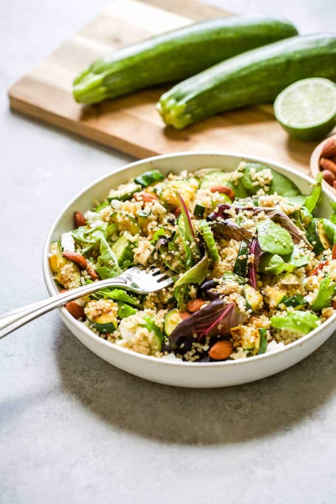 quinoa salad with greens, zucchini, cucumbers, almonds and feta