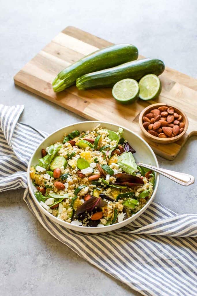 quinoa salad in a white bowl with a fork