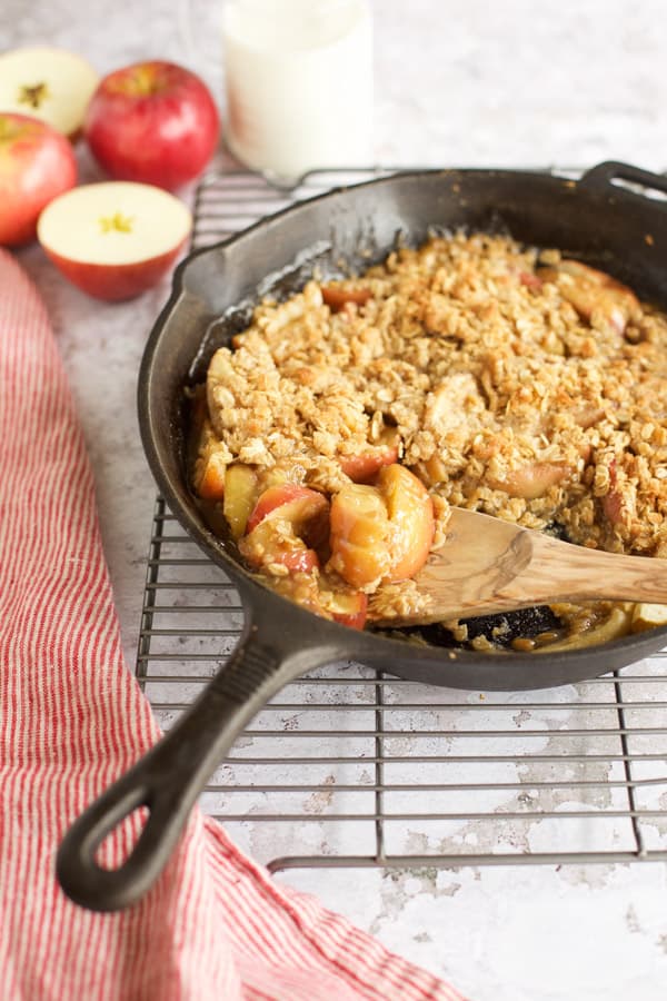 flourless gluten free apple crisp in skillet with milk