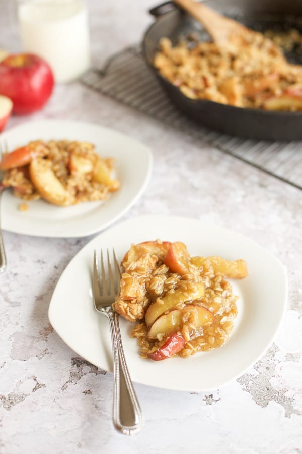 gluten free apple crisp on a white plate with a fork