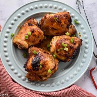 Pieces of soy glazed chicken thighs served on a plate.