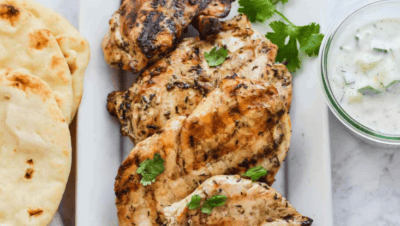 Grilled chicken souvlaki on a white plate.