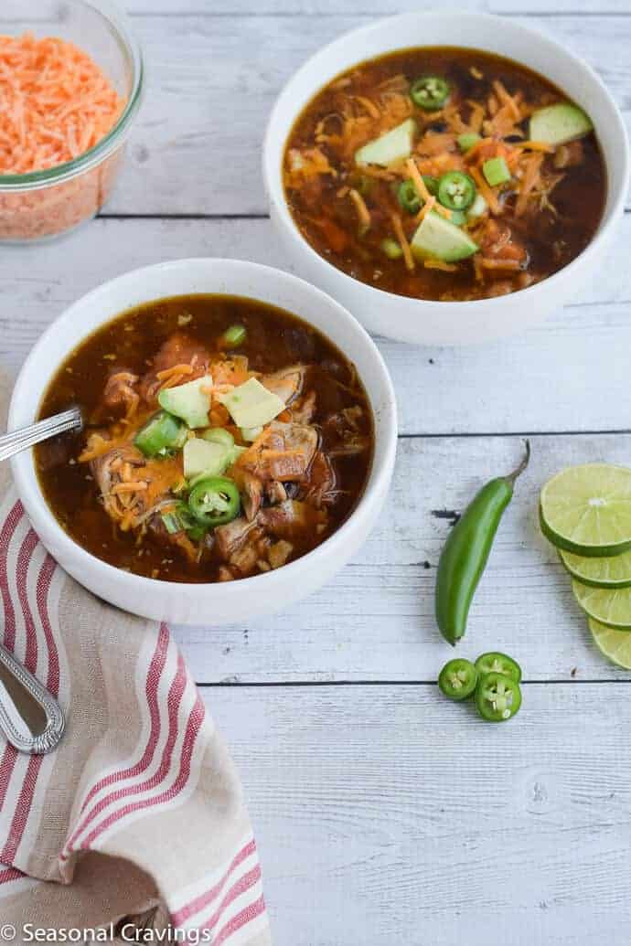 Slow Cooker Mexican Chicken Tortilla Soup with avocado, jalapenos and cheese in two small white serving bowls. #crockpot #glutenfree