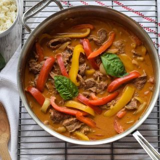 This recipe features an easy Thai beef curry cooked in a pan along with flavorful peppers, served over rice.