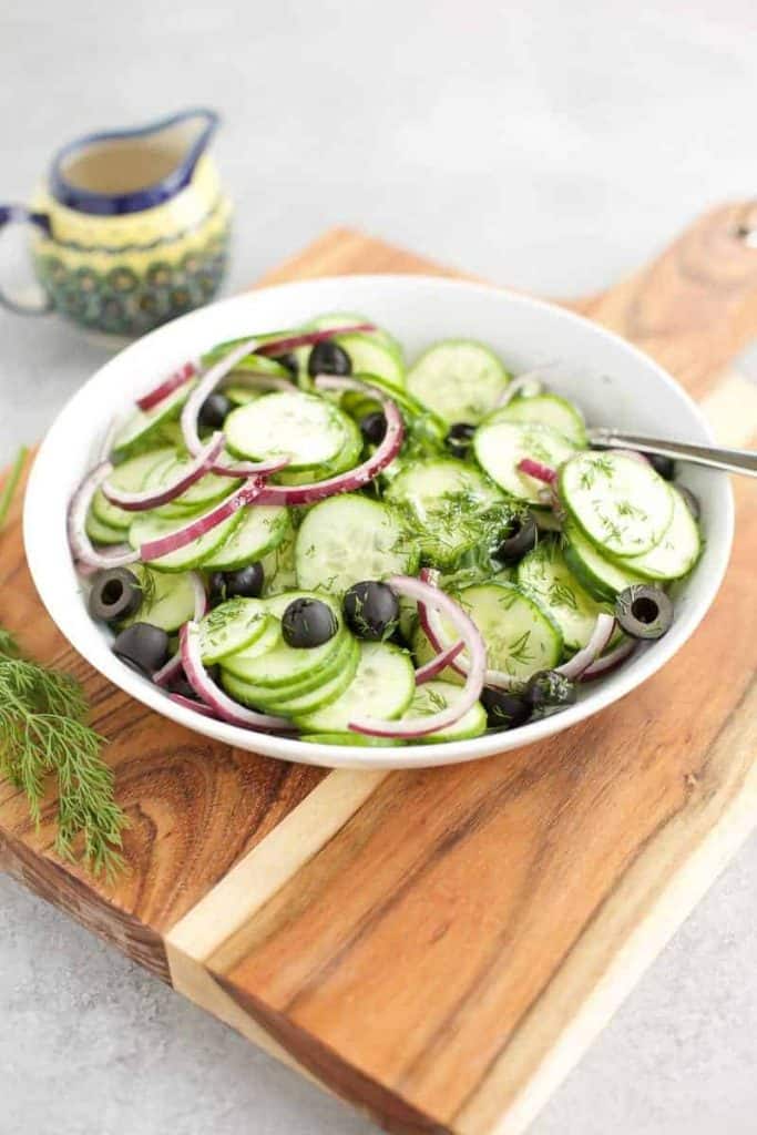 Cucumber Salad {Keto} in a white bowl on a cutting board