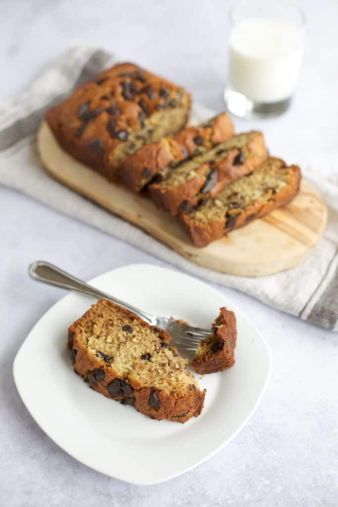 best gluten free banana bread with milk and bite on a fork