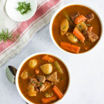 Two bowls of gluten-free instant pot beef stew with carrots and potatoes.