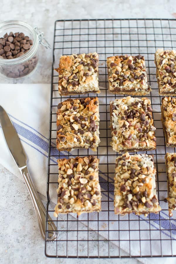 Gluten Free Seven Layer Bars on a cooling rack with a knife.