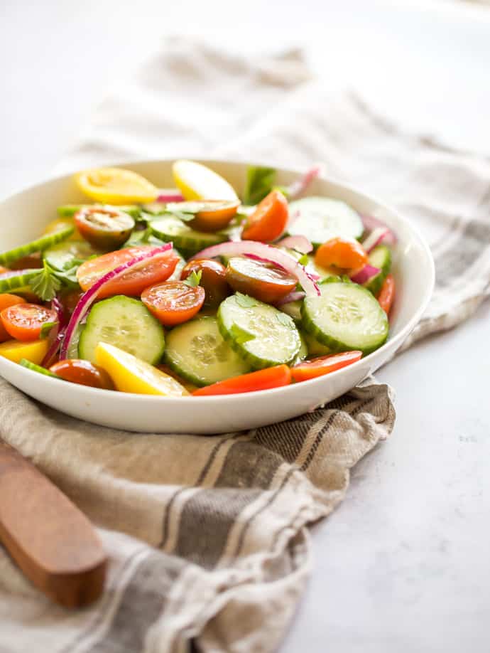 cucumber, tomato and onion salad with wooden spoon