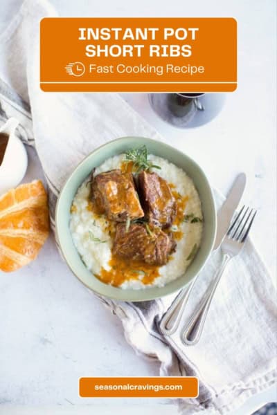 A bowl of Instant Pot short ribs with gravy served over creamy mashed potatoes. A roll is seen on the side, with a fork and knife placed on a gray napkin. Text overlay reads "Instant Pot Short Ribs, Fast Cooking Recipe.