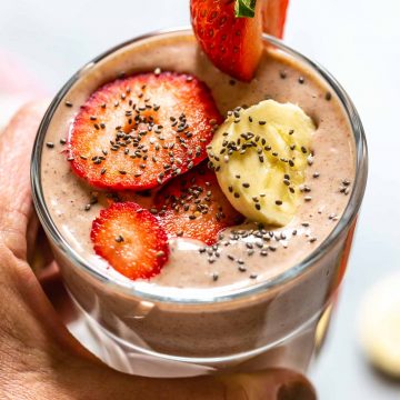 close up of smoothie with a hand