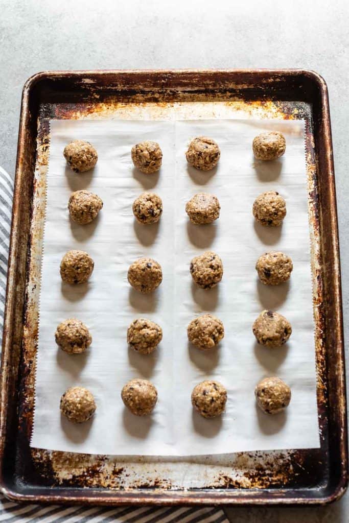 snack balls on parchment paper on a cookie sheet