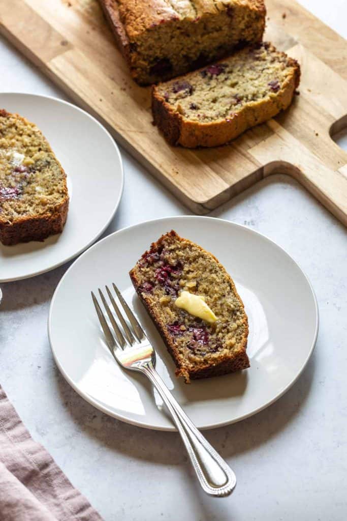 gluten free blackberry banana bread on a wooden board with two slices cut