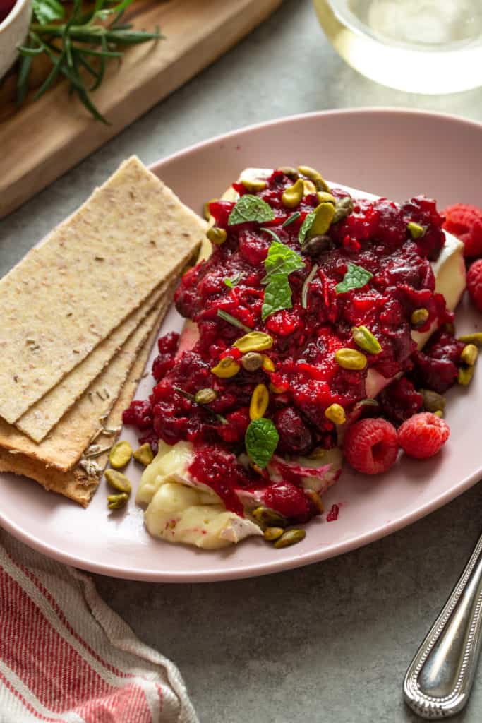 close up of baked brie with crackers on the side