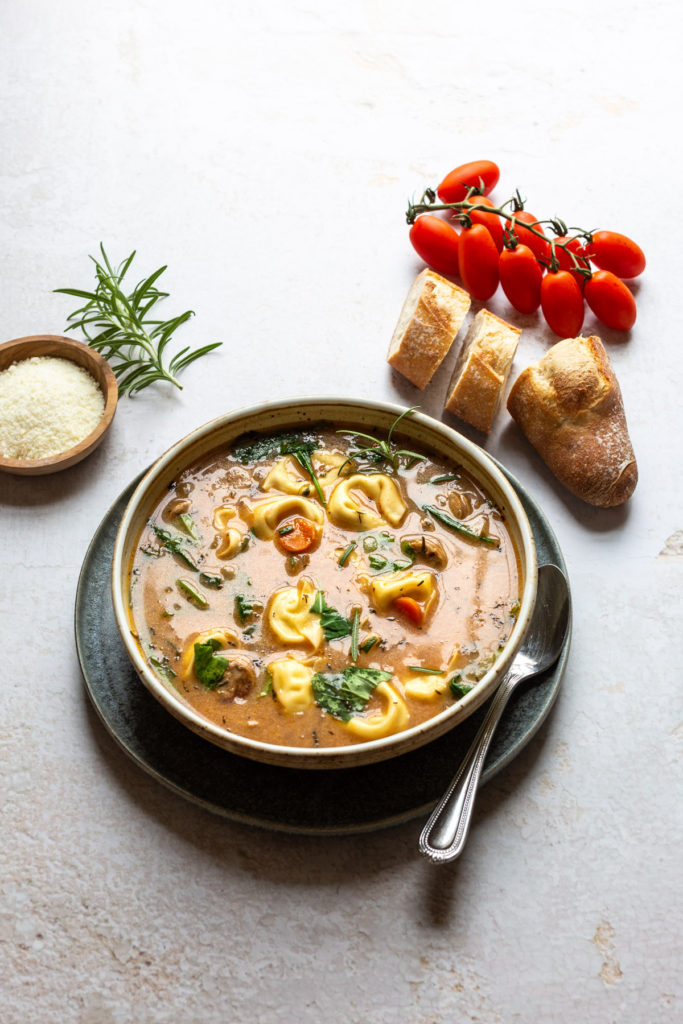 tortellini soup with sausage and cheese on the side