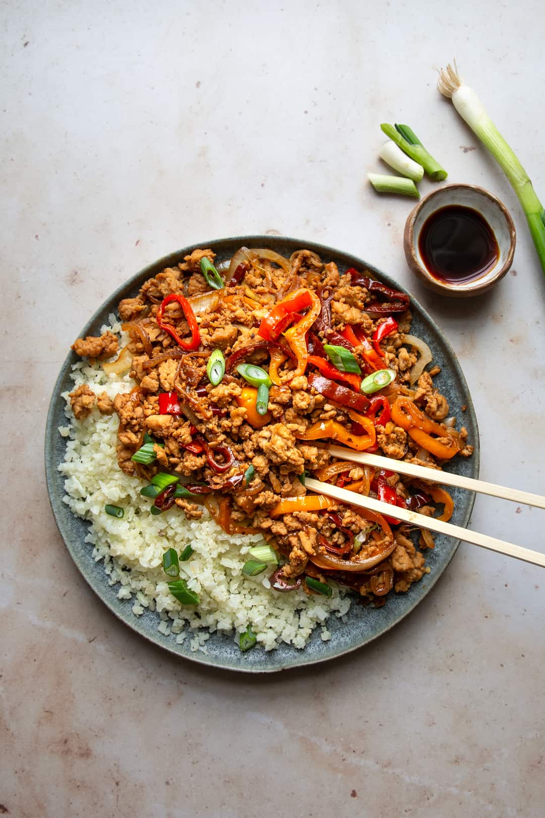 Gluten-free Chinese chicken stir fry on a plate with chopsticks.