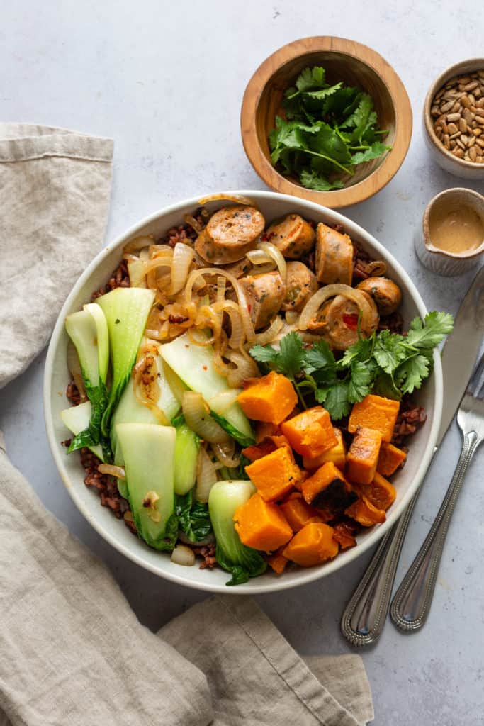 sausage grain bowl with tahini dressing and bok choy in a bowl 