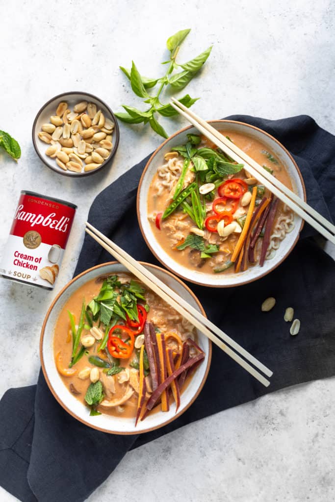 creamy thai chicken ramen with two bowls and chopsticks