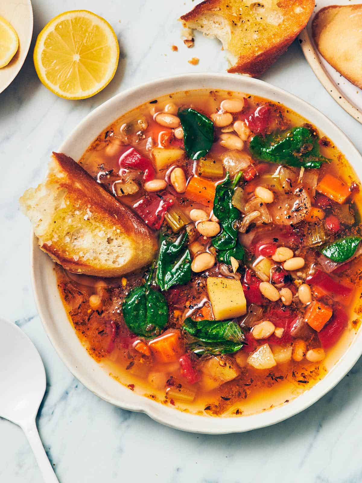 A bowl of soup with a slice of bread next to it.