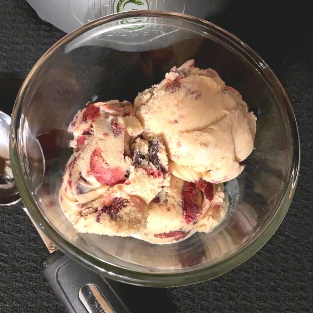 A bowl of ice cream with strawberries in it.