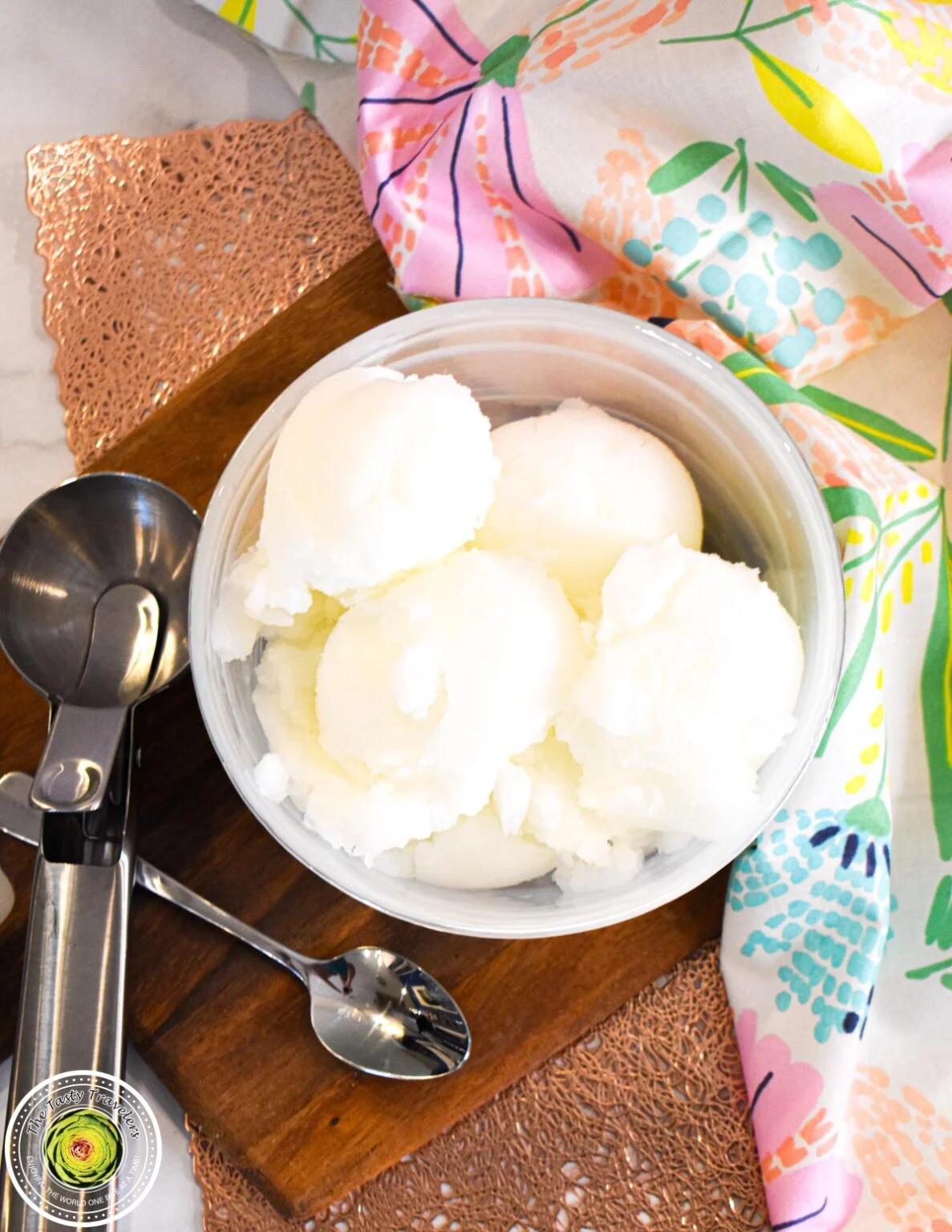 A bowl of Italian ice cream and a spoon on a table.