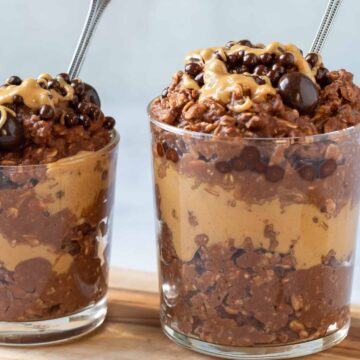 Chocolate oatmeal in two glasses with spoons.