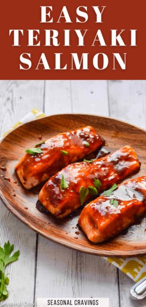 A wooden plate with three pieces of teriyaki salmon in oven, covered in rich teriyaki sauce. Parsley is used as garnish, and a yellow cloth is partially visible underneath the plate. "Easy Teriyaki Salmon" text is on top.