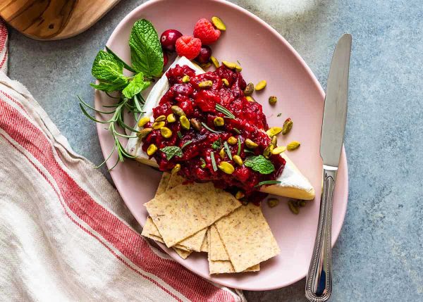 Melted brie cheese with cranberry raspberry sauce on top.