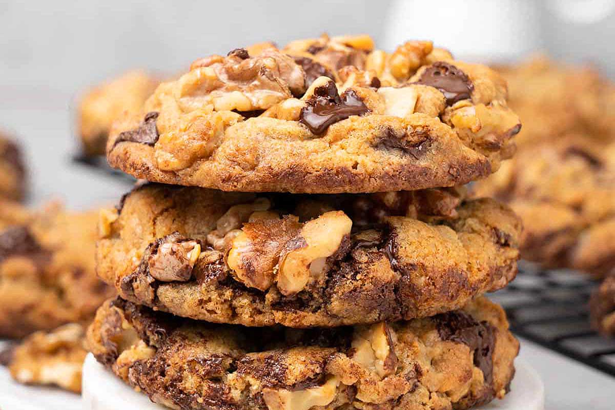 A stack of chocolate chip cookies on a cooling rack.