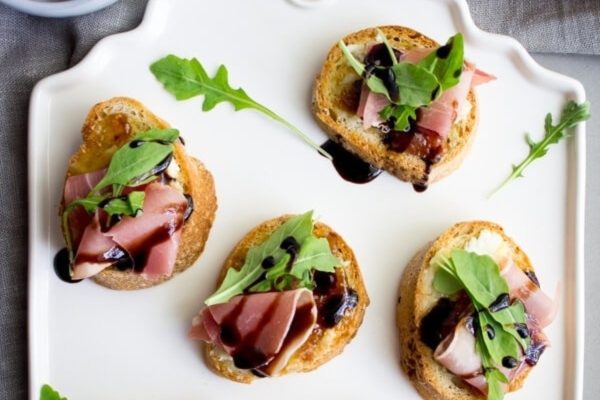 Ham and arugula crostini with balsamic vinaigrette.