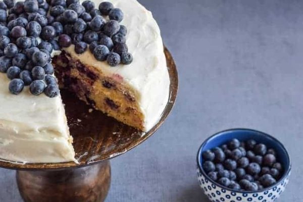 A blueberry cake with a slice taken out.