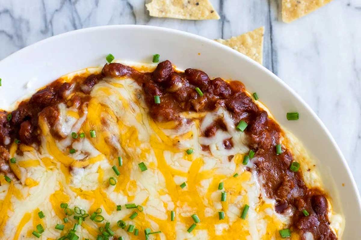 Cheesy chili dip in a white bowl.