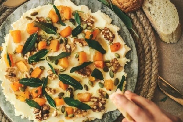 A plate with squash and walnuts on it.