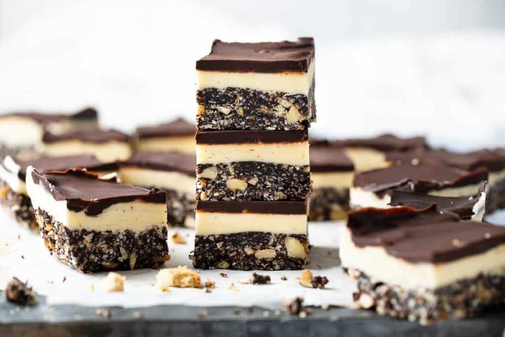 A stack of Nanaimo bars on a baking sheet pan. 