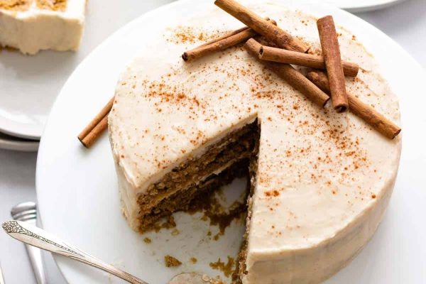 A slice of cake with cinnamon sticks on a plate.