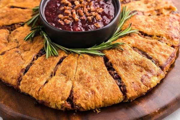 Cranberry cranberry bread with cranberry sauce on a wooden plate.