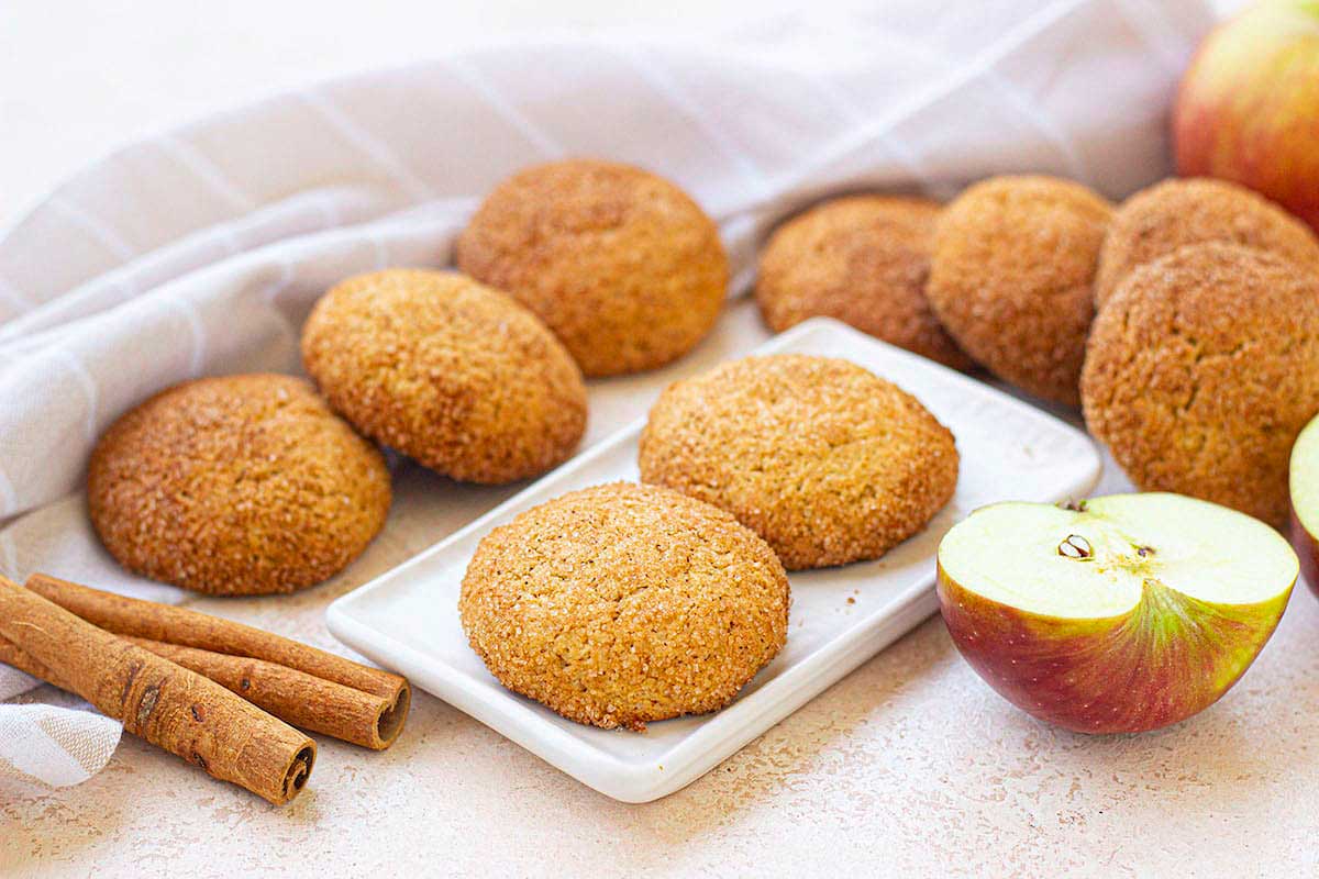 Apples and cinnamon on a white plate.