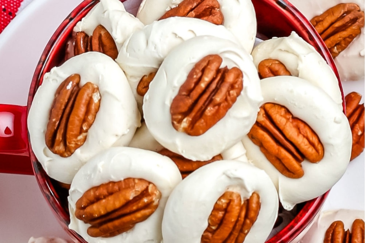 Christmas pecan cookies in a red bowl.