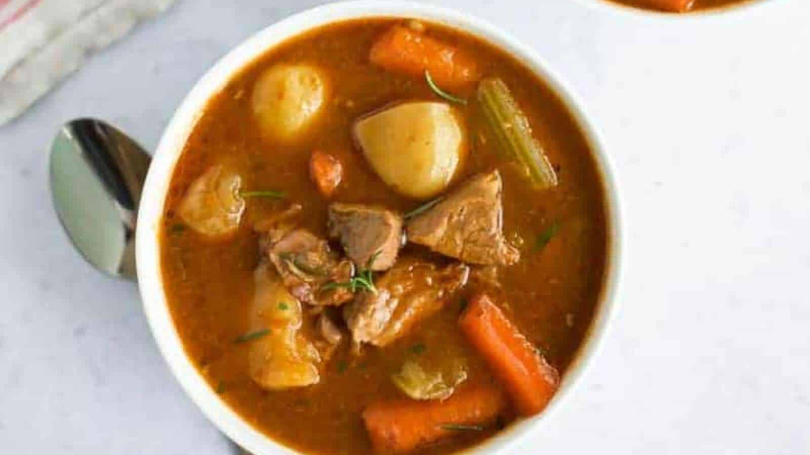 A bowl of beef stew with potatoes and carrots.