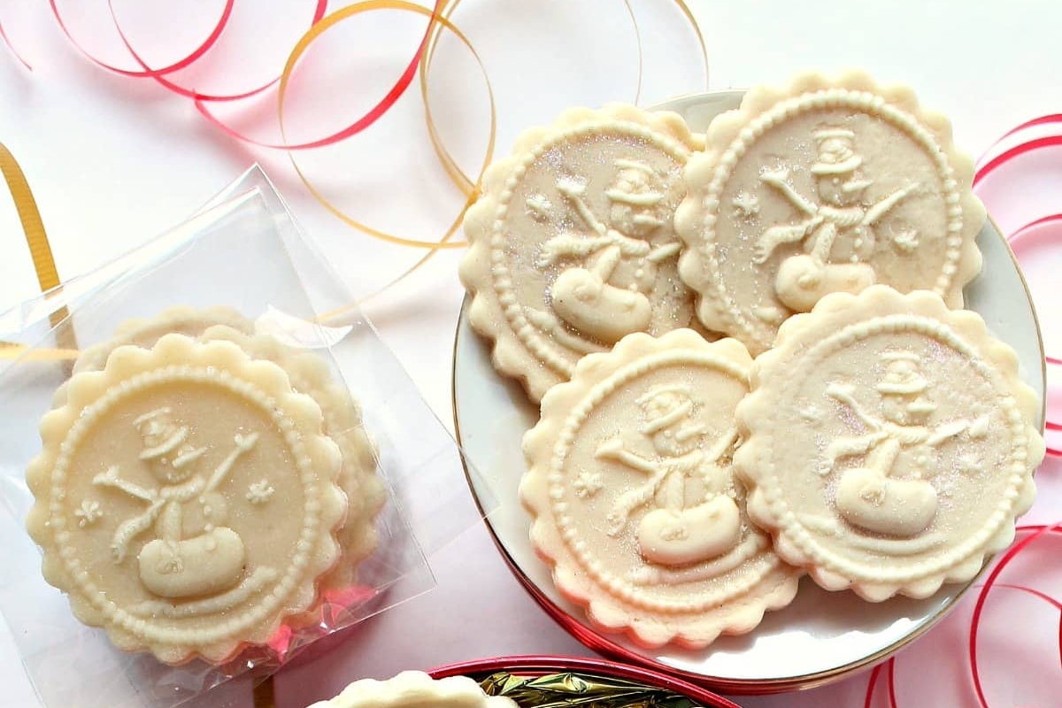 Christmas snowman cookies in a box with ribbons and bows.