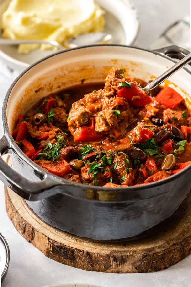 A delicious pot of stew, prepared with tender chunks of chuck steak and an assortment of vibrant vegetables, placed enticingly on a table.