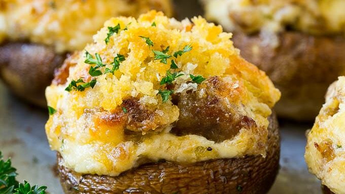 Cheesy stuffed mushrooms on a baking sheet.