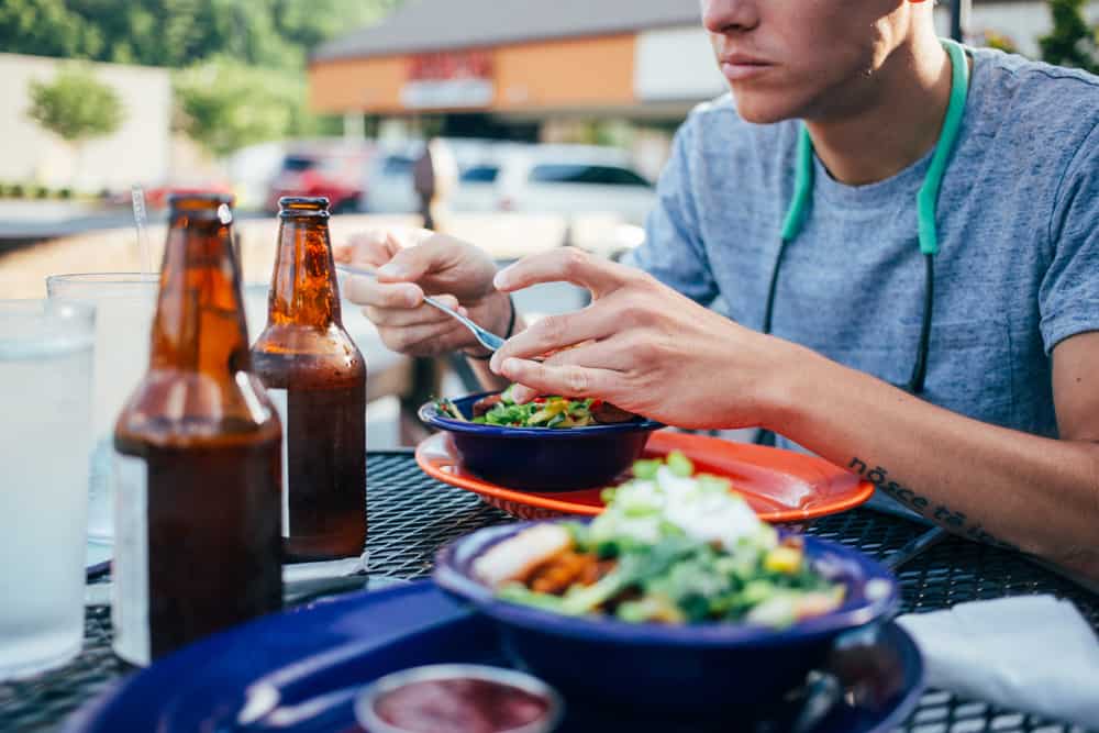 A man sitting at a table with a bowl of Chipotle's gluten-free food.