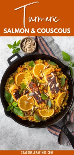 Top-down view of a cast iron skillet containing turmeric-seasoned salmon fillets and couscous garnished with orange slices, fresh herbs, and slivered almonds. Text reads: "Turmeric Salmon & Couscous.