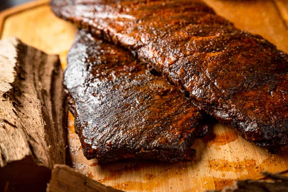 Texas Roadhouse Bbq ribs on a wooden cutting board.