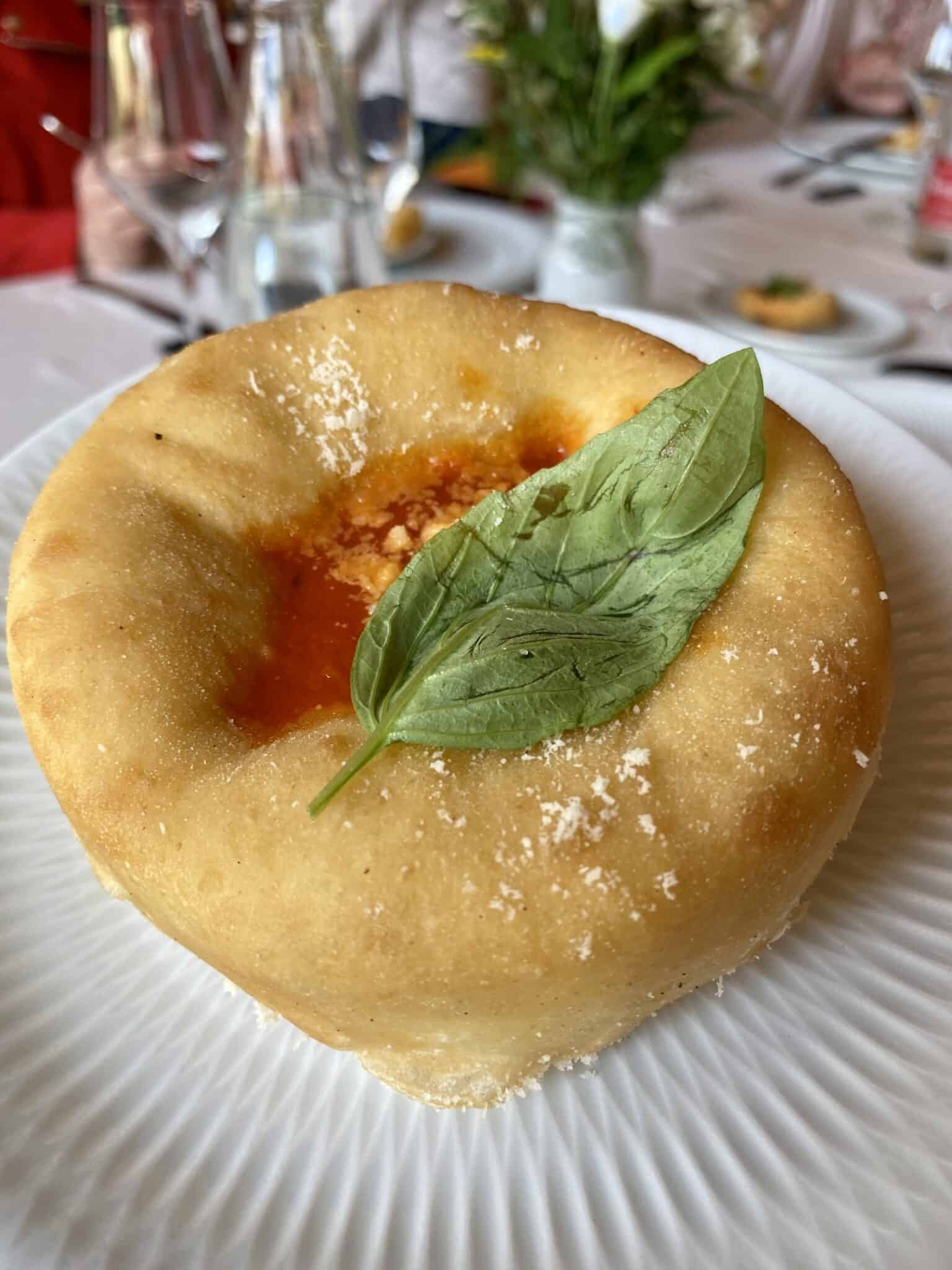 A pizza with a basil leaf on top of it, featuring a unique donut flavors twist.