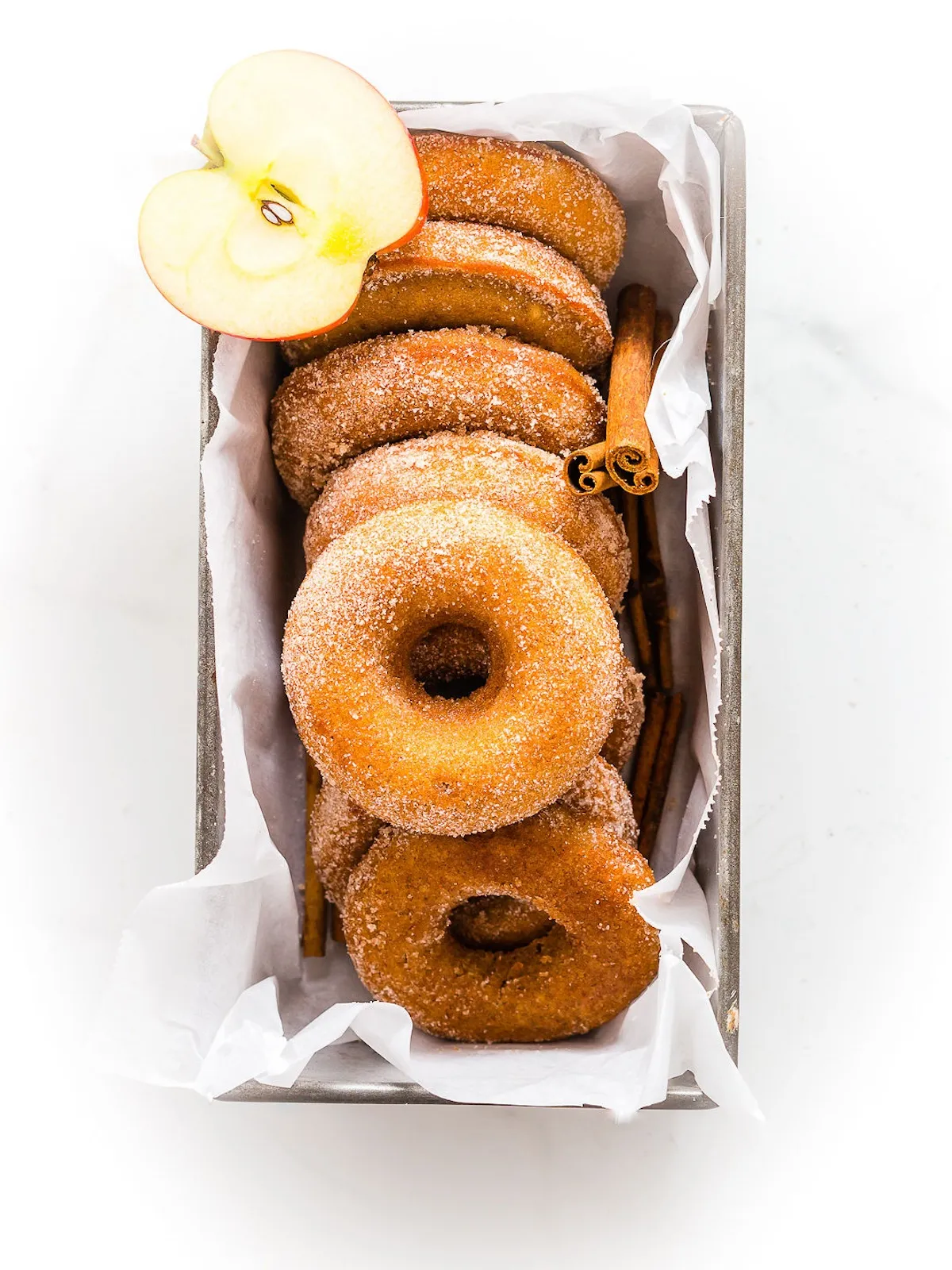 Donuts in a box with unique donut flavors and cinnamon.