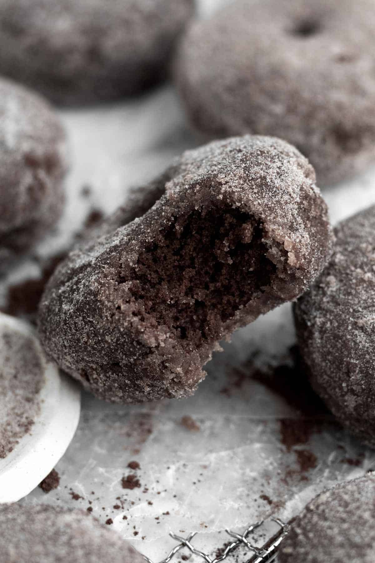 Unique chocolate donuts with a bite taken out of them.