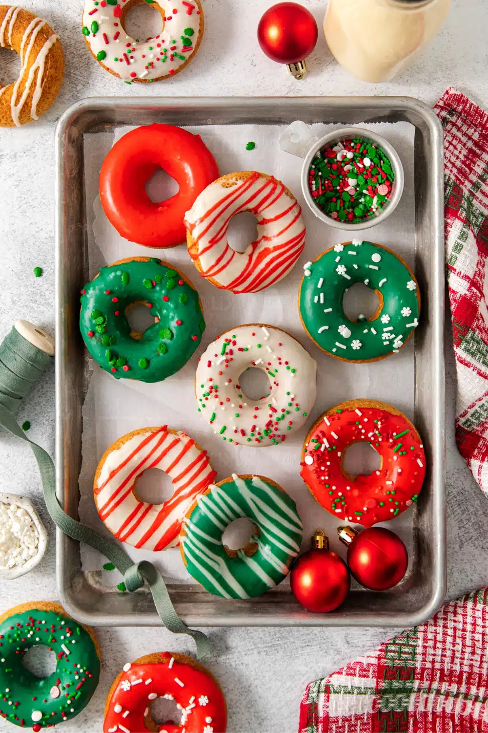 Unique donut flavors on a tray with Christmas decorations.