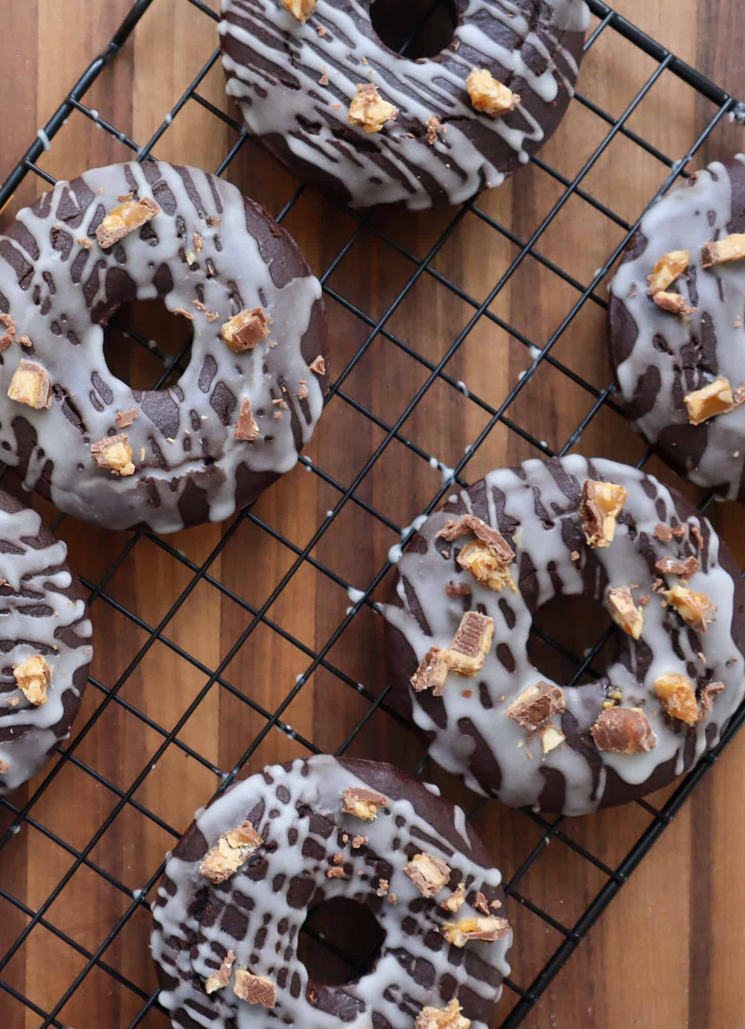 Unique chocolate glazed donuts on a cooling rack.